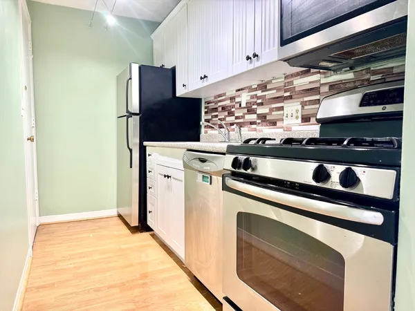 a view of kitchen with refrigerator and cabinets