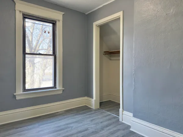 an empty room with wooden floor and a window
