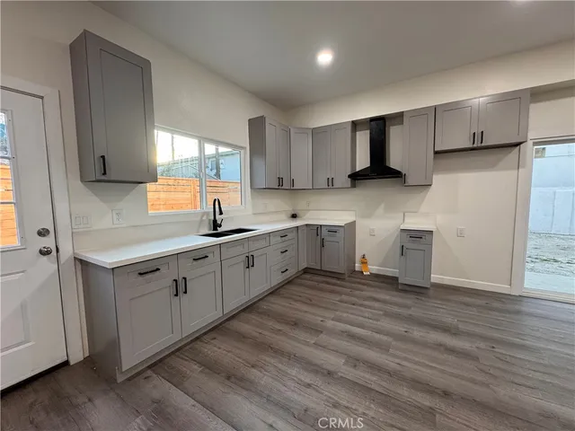 a kitchen with a sink cabinets and wooden floor