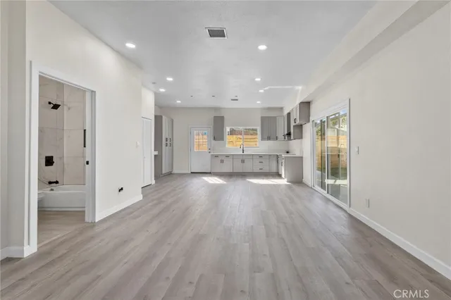 a view of a kitchen with wooden floor and a window