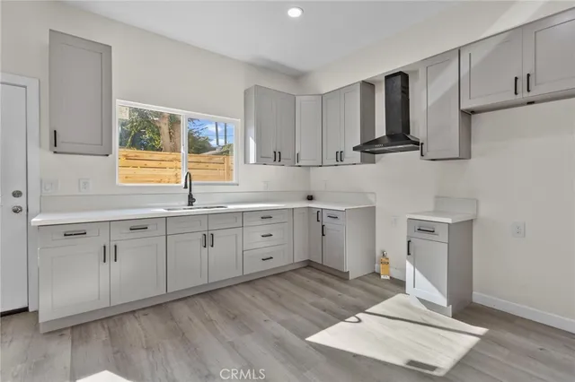 a kitchen with cabinets stainless steel appliances a sink and wooden floor