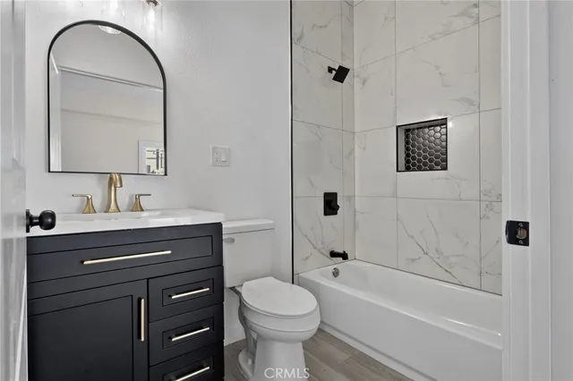 a bathroom with a toilet sink vanity tub and shower