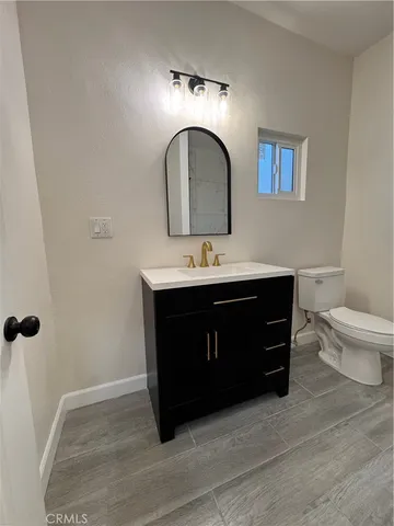 a bathroom with a sink vanity and toilet