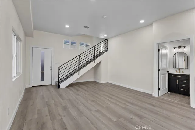 a view of a hallway with wooden floor and stairs