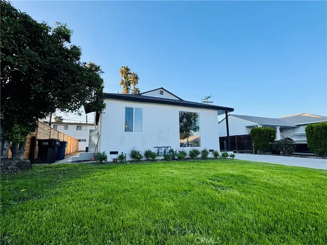 a view of a house with a yard and sitting area