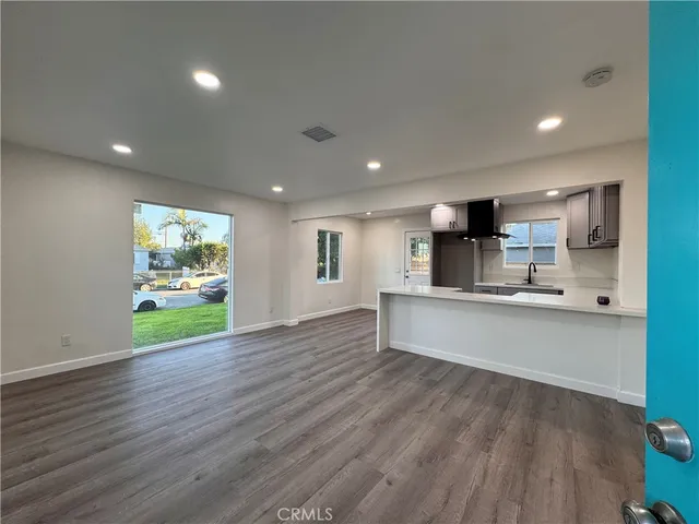 a view of kitchen with wooden floor and electronic appliances