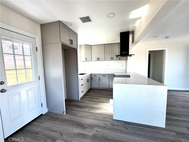 a living room with stainless steel appliances kitchen island granite countertop a stove a refrigerator a sink a dining table and chairs