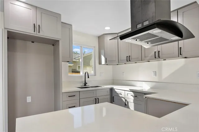 a kitchen with stainless steel appliances kitchen island a sink a stove and white cabinets