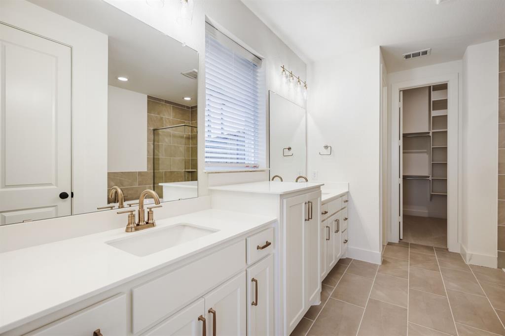 4314 Haley Way Oak Point, TX 75068 - Photo 20 of 28 Dual vanity with white cabinetry, integrated sinks, and brushed bronze fixtures