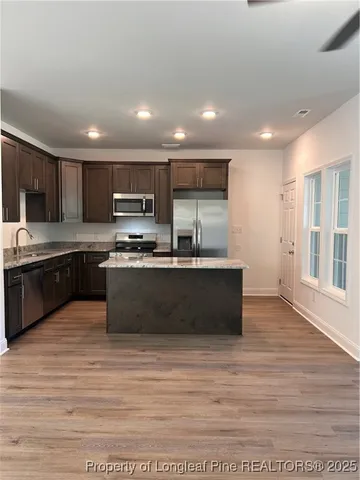 a large kitchen with granite countertop a stove top oven a sink dishwasher a dining table and chairs