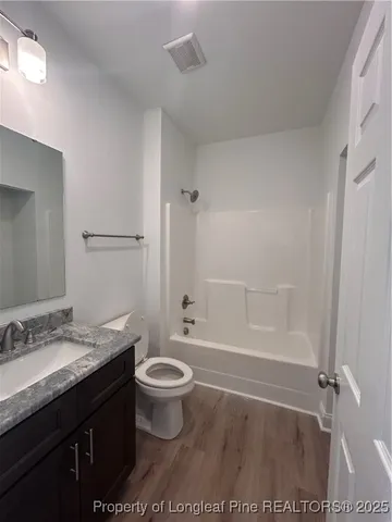 a bathroom with a granite countertop sink toilet a mirror and shower