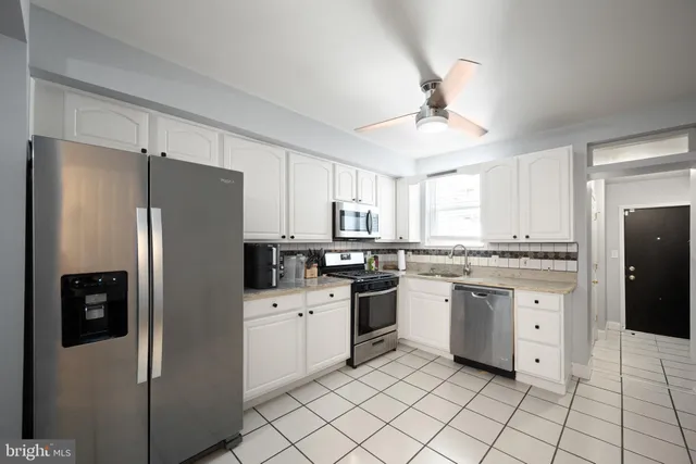 a kitchen with granite countertop appliances cabinets and a counter space