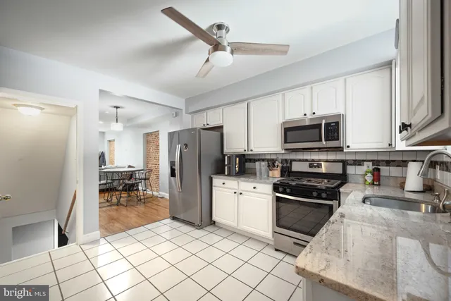 a kitchen with stainless steel appliances granite countertop a refrigerator a stove top oven a sink and dishwasher