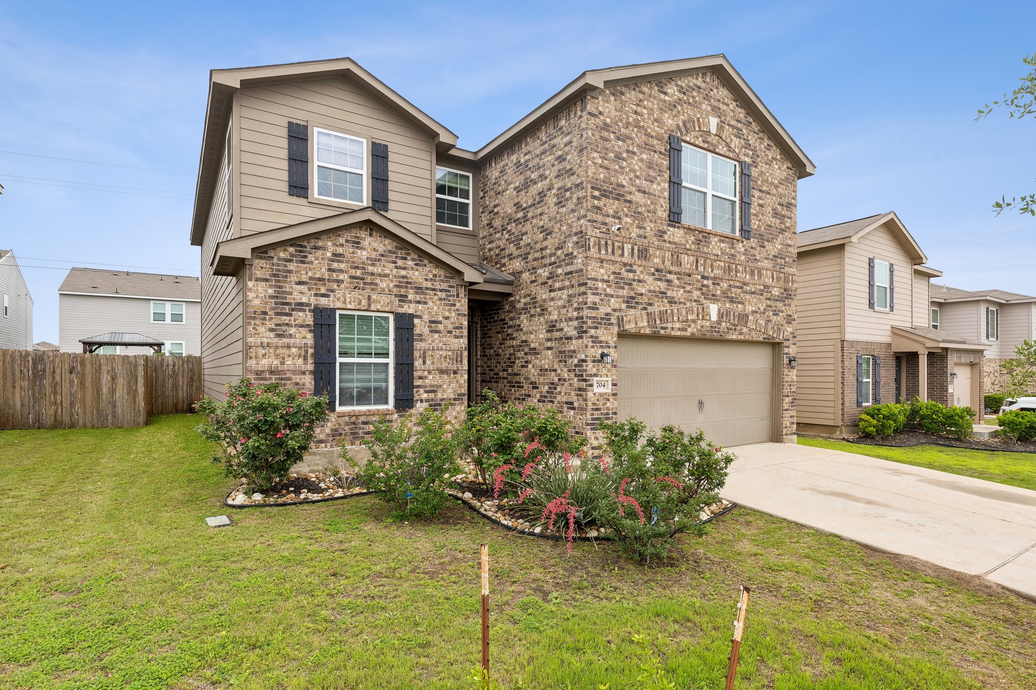 704 Cleary Lane Jarrell, TX 76537 - Photo 1 of 25 Two-story residence featuring a brick and siding exterior, an attached garage, and a concrete driveway