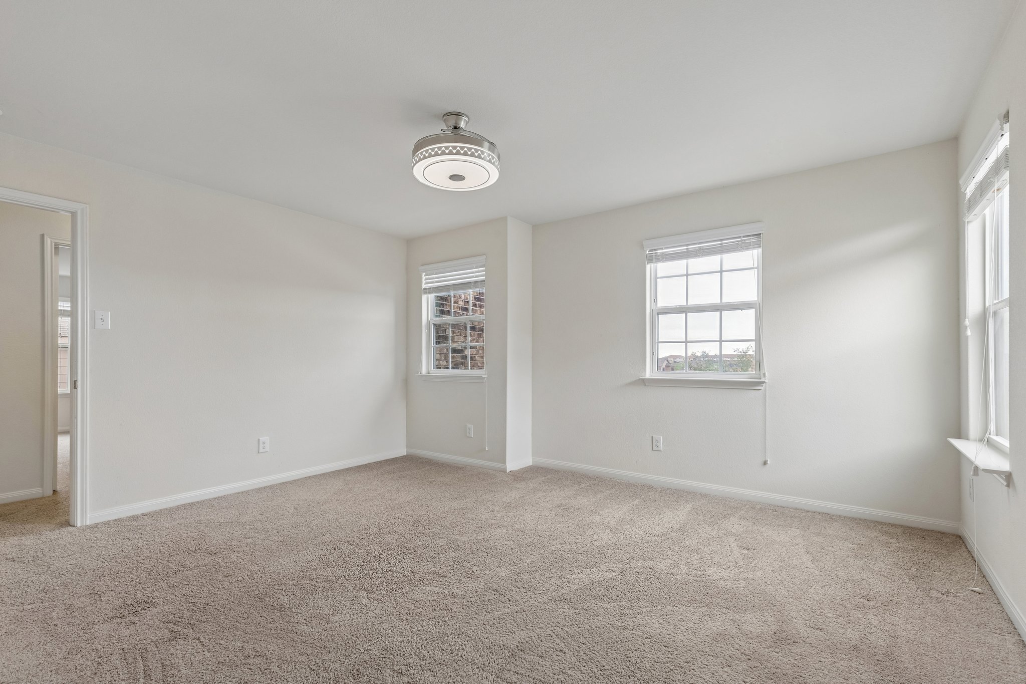 704 Cleary Lane Jarrell, TX 76537 - Photo 19 of 25 Spacious interior room with neutral-toned carpet, light wall finishes, and a contemporary flush-mount ceiling fixture