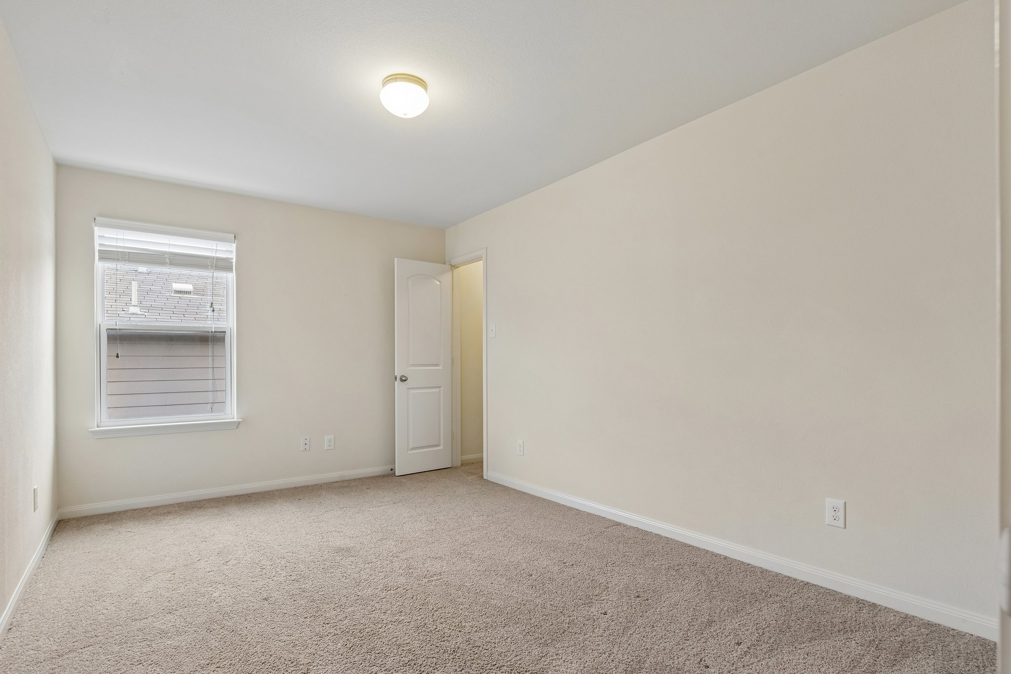 704 Cleary Lane Jarrell, TX 76537 - Photo 21 of 25 Carpeted interior space with a window featuring blinds, an interior door, and a ceiling-mounted light fixture