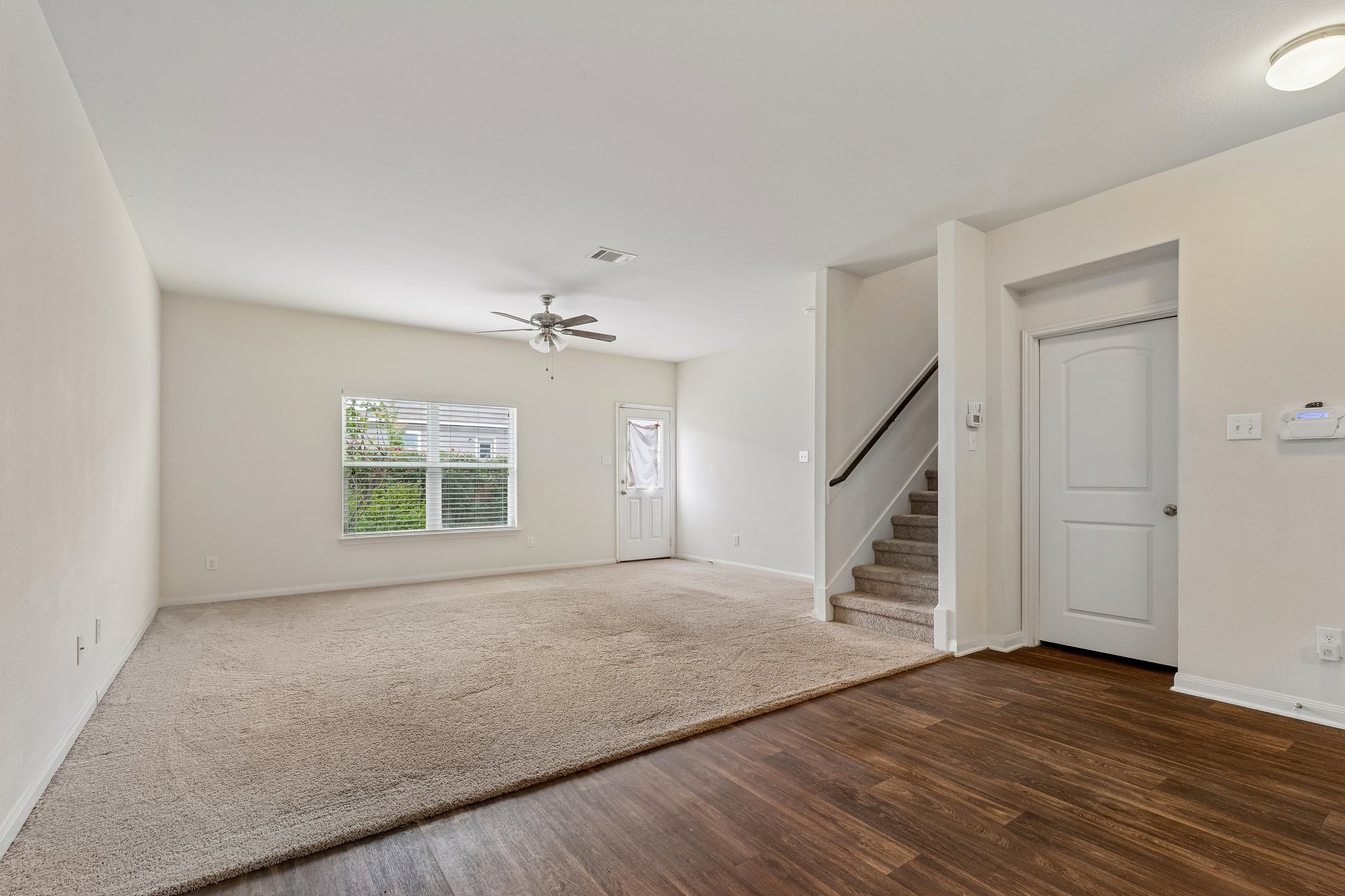 704 Cleary Lane Jarrell, TX 76537 - Photo 4 of 25 Spacious living area featuring a ceiling fan, a window with blinds, and carpet flooring
