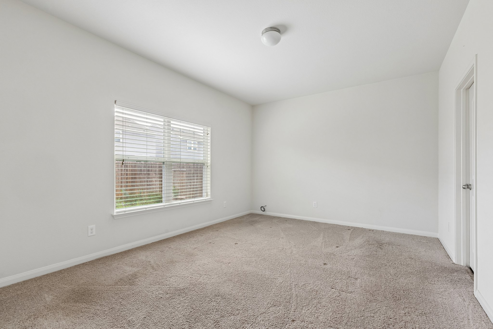 704 Cleary Lane Jarrell, TX 76537 - Photo 6 of 25 Carpeted room featuring a single window with horizontal blinds, a flush mount ceiling light fixture, white walls, and a white interior door