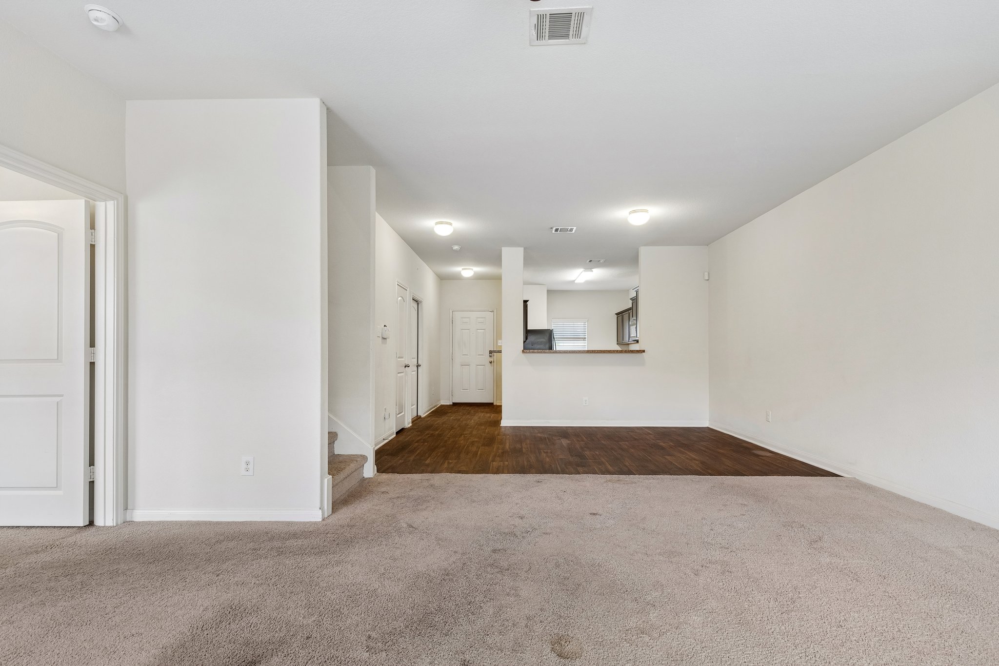 704 Cleary Lane Jarrell, TX 76537 - Photo 10 of 25 Spacious open-concept interior featuring light-toned walls and a combination of carpeting and wood-finish flooring