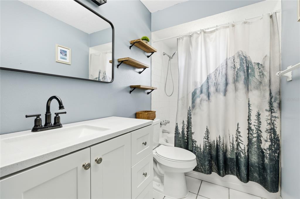 3670 Sunset Beach Drive Venice, FL 34293 - Photo 20 of 51 a bathroom with a sink a toilet and shower curtain