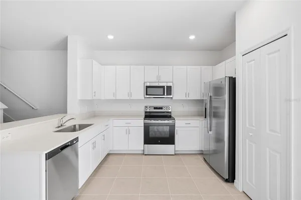 a kitchen with stainless steel appliances kitchen island granite countertop a stove a sink a dining table and chairs