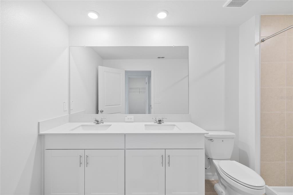 36148 Risa Michele Street Zephyrhills, FL 33541 - Photo 20 of 34 a bathroom with a sink a toilet and mirror