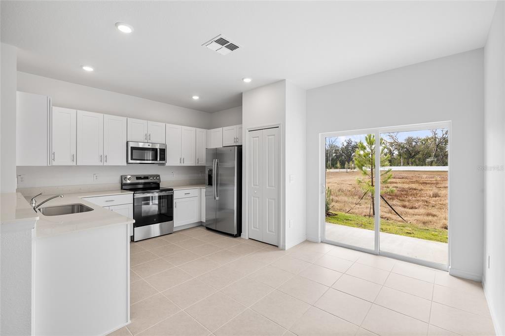 36148 Risa Michele Street Zephyrhills, FL 33541 - Photo 10 of 34 a kitchen with stainless steel appliances a refrigerator sink and microwave