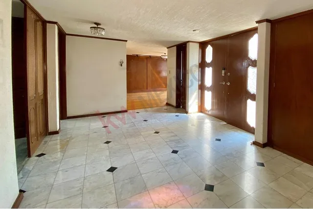 a view of a hallway with wooden floor and a living room