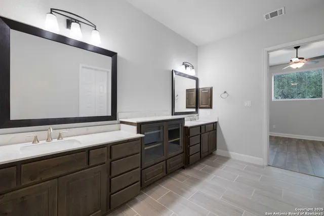 a bathroom with double vanity sink and a mirror