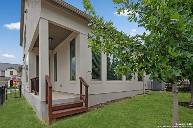 a view of backyard with white house and a large tree