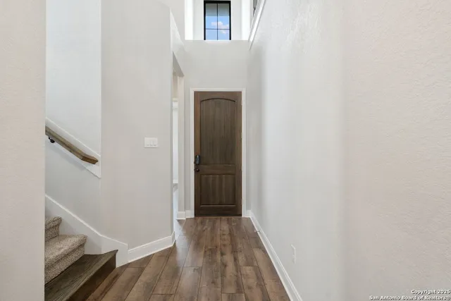 a view of a hallway with wooden floor and staircase