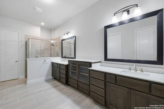 a bathroom with double vanity and a mirror