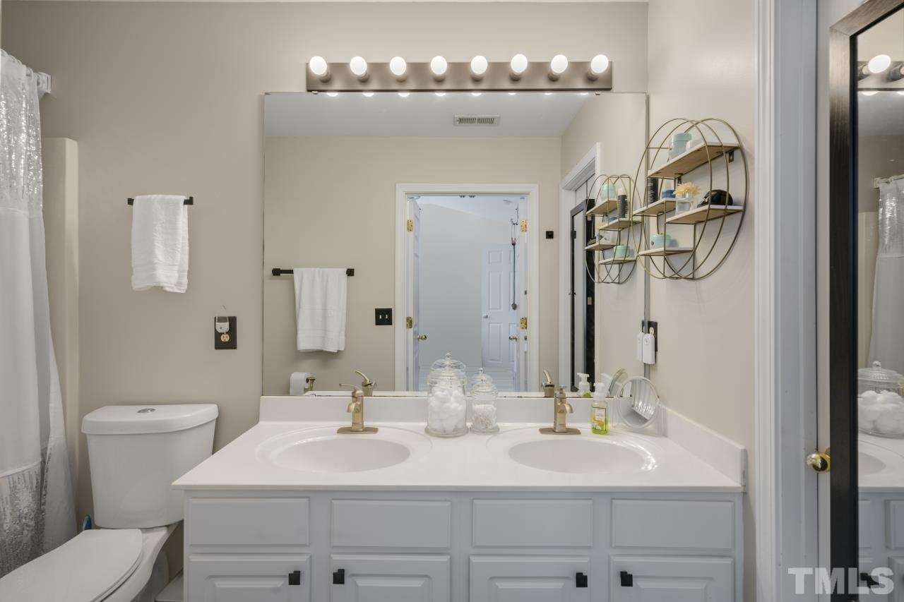 7106 Proctor Hill Drive Raleigh, NC 27613 - Photo 21 of 29 a bathroom with a sink a toilet and a mirror