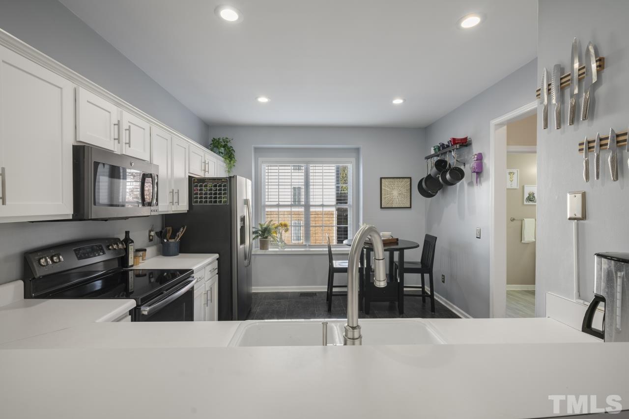 7106 Proctor Hill Drive Raleigh, NC 27613 - Photo 9 of 29 a kitchen with stainless steel appliances kitchen island granite countertop a refrigerator and microwave