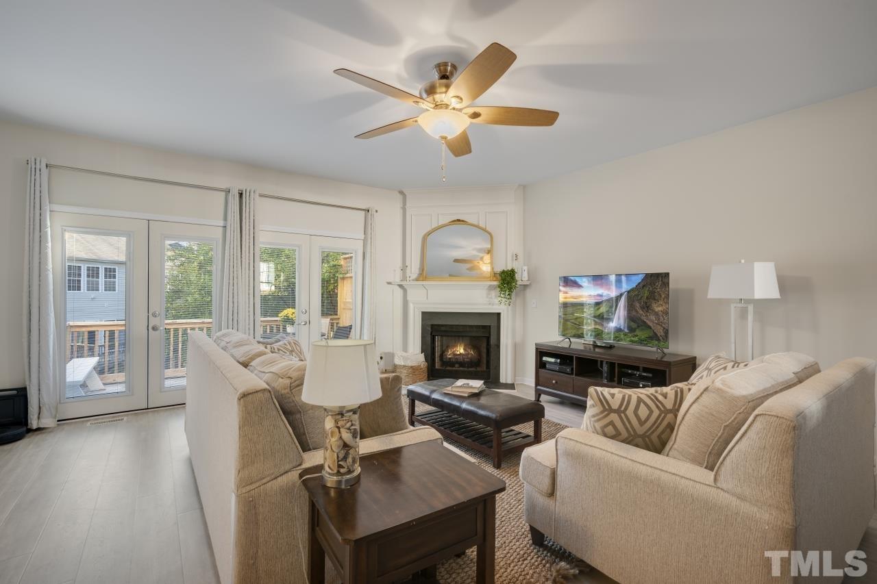 7106 Proctor Hill Drive Raleigh, NC 27613 - Photo 10 of 29 a living room with furniture a fireplace and a chandelier