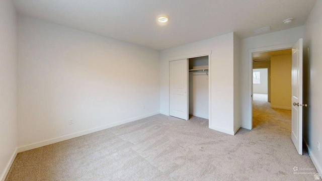 777 Pheasantbrook Drive, Unit 2B Centerville, UT 84014 - Photo 26 of 42 Carpeted room with white walls, featuring a bi-fold closet with hanging rod, a flush-mount ceiling light, and white trim throughout