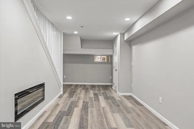 a view of hallway with stairs and wooden floor