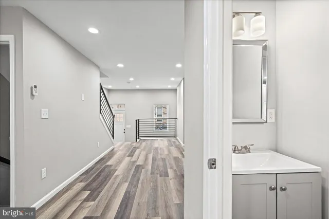 a view of a hallway with wooden floor and staircase