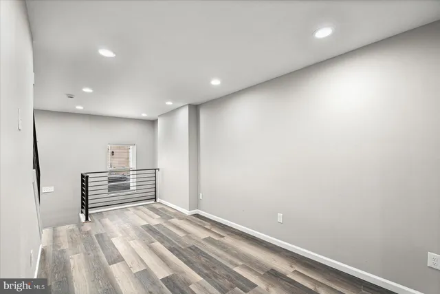 a view of a hallway with wooden floor and a window