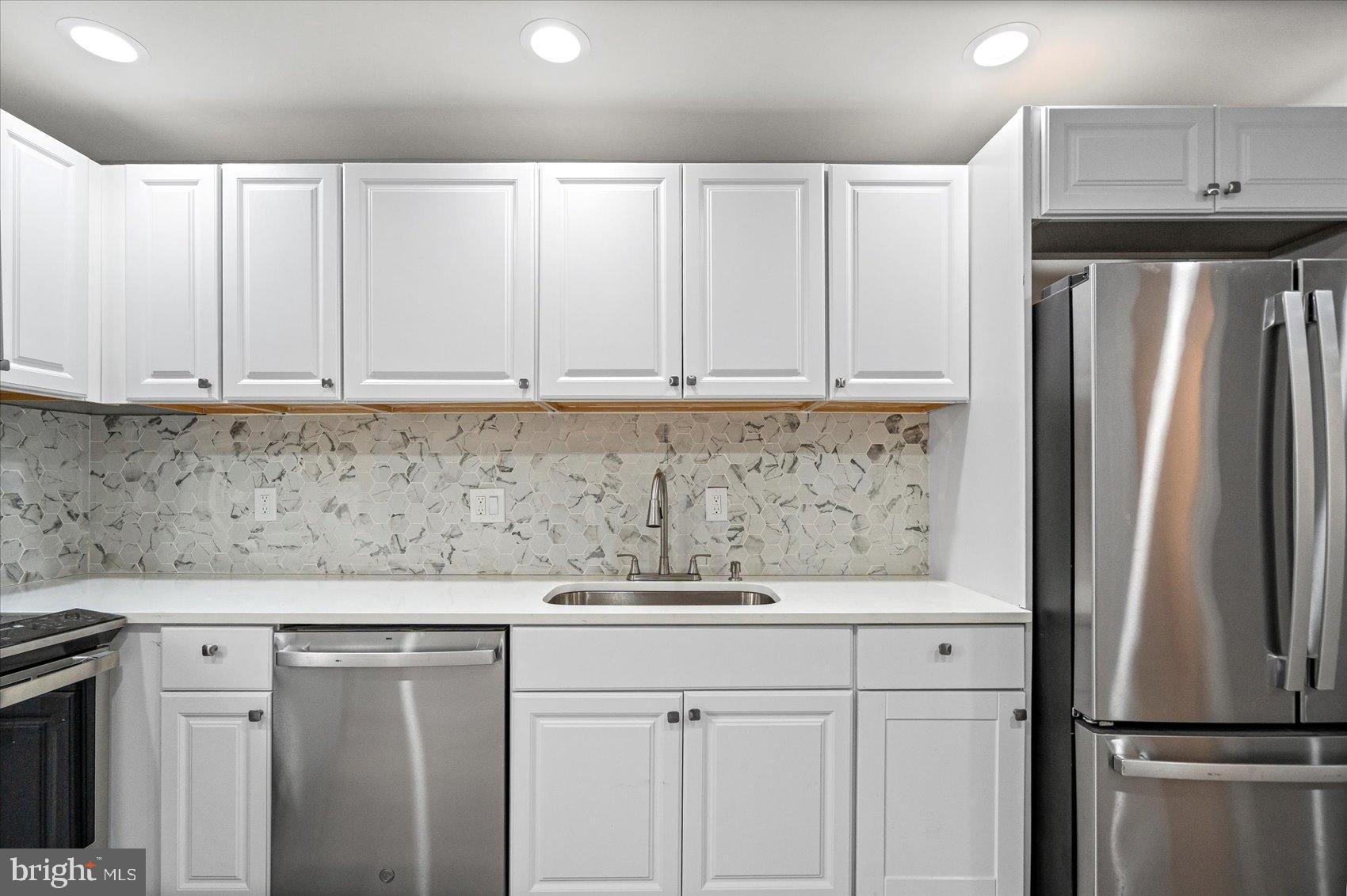 407 Pitman Place Baltimore, MD 21202 - Photo 9 of 42 a kitchen with stainless steel appliances granite countertop a refrigerator a stove and white cabinets