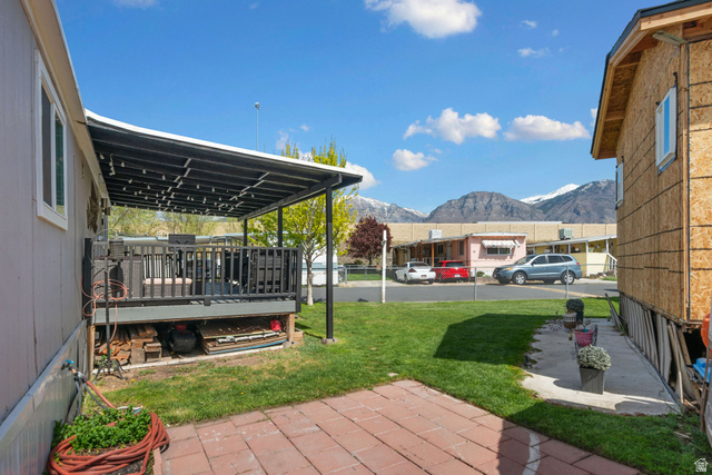 255 North 1600 West, Unit 60 Provo, UT 84601 - Photo 19 of 22 View of green lawn with a patio area and a deck with mountain view