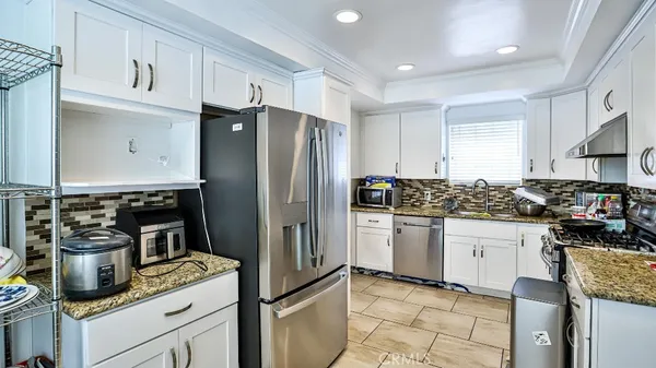 a kitchen with stainless steel appliances granite countertop a refrigerator sink and stove