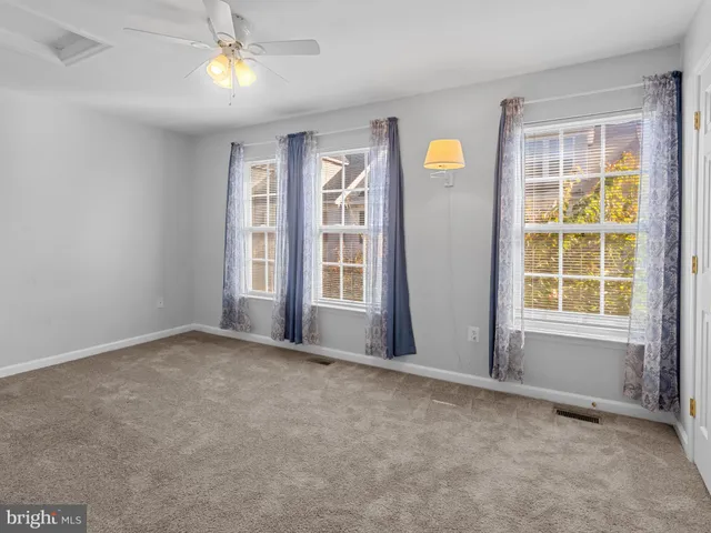 an empty room with windows cabinet and balcony