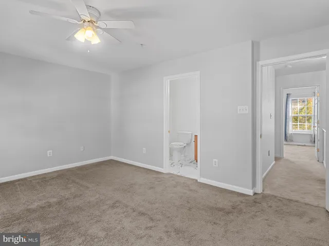 an empty room with closet and a ceiling fan