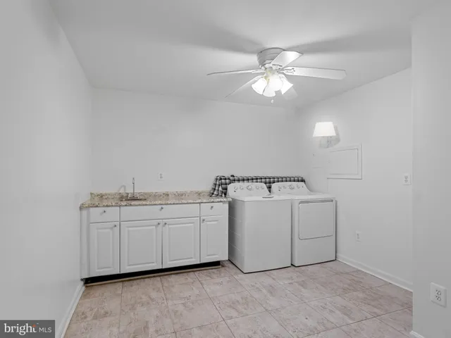a bathroom with a granite countertop sink and cabinets
