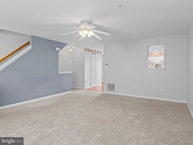 a view of an empty room with a chandelier fan
