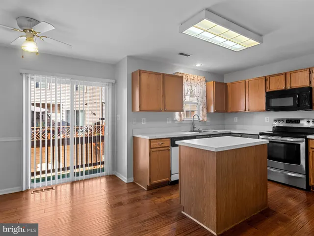 a kitchen with wooden floors and white cabinets