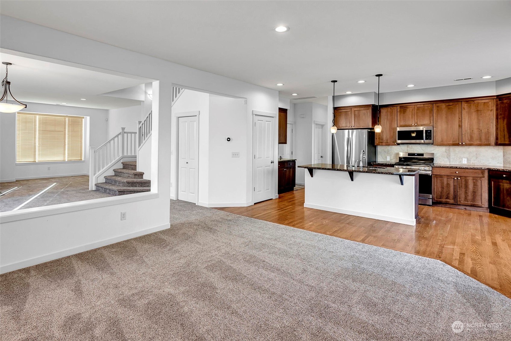 4812 Northeast 2nd Place Renton, WA 98059 - Photo 7 of 26 a large white kitchen with kitchen island a sink stainless steel appliances and cabinets