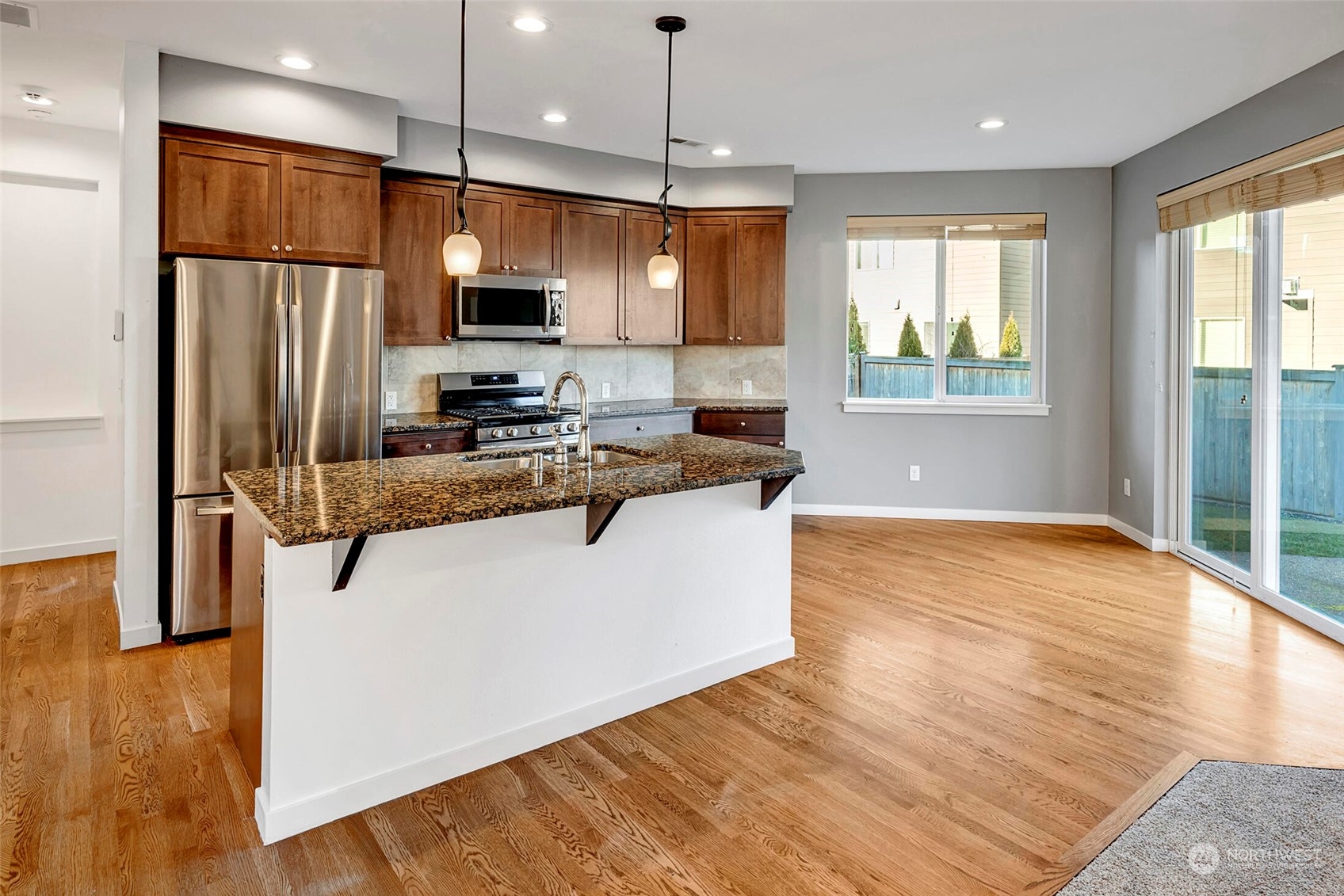 4812 Northeast 2nd Place Renton, WA 98059 - Photo 8 of 26 a kitchen with stainless steel appliances granite countertop a refrigerator a stove top oven a sink dishwasher and wooden floor