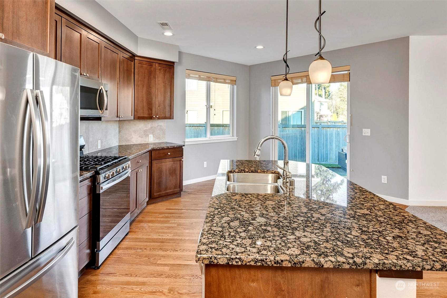 4812 Northeast 2nd Place Renton, WA 98059 - Photo 9 of 26 a kitchen with stainless steel appliances granite countertop a sink a stove and a refrigerator
